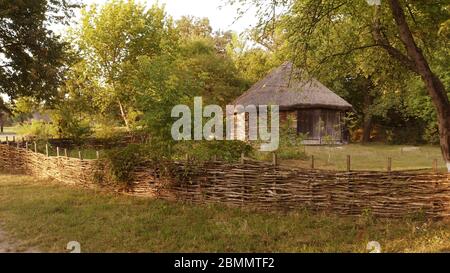 Petite maison en rondins clôturée par une clôture peu arrosée dans la forêt. Banque D'Images