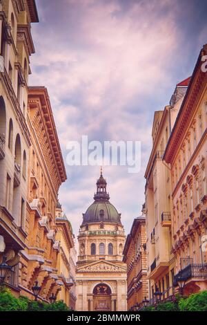 Basilique Saint-Étienne à Budapest lors d'une belle journée vue depuis la rue touristique à pied à travers les bâtiments. Banque D'Images