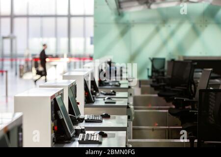 Rangée de comptoirs d'enregistrement avec moniteurs informatiques au terminal d'aéroport vide en raison d'une pandémie de coronavirus/épidémie de Covid-19. Mise au point sélective. Interdiction de voyager. Banque D'Images