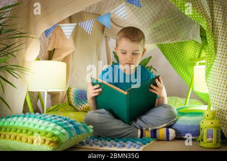 lecture et jeux de famille dans la tente pour enfants. Garçon avec livre avant d'aller au lit Banque D'Images