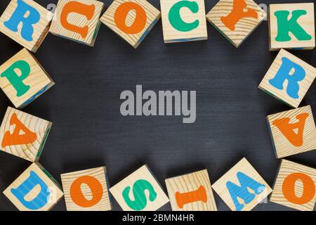 Blocs de bois à l'alphabet coloré sur fond noir tableau noir. Pose à plat Banque D'Images