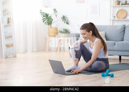 Bonne fille en vêtements de sport prêt pour l'entraînement en ligne Banque D'Images