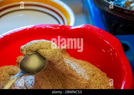 Prendre la pâte de blé et le sarrasin à la cuillère pour cuire les beignets Banque D'Images
