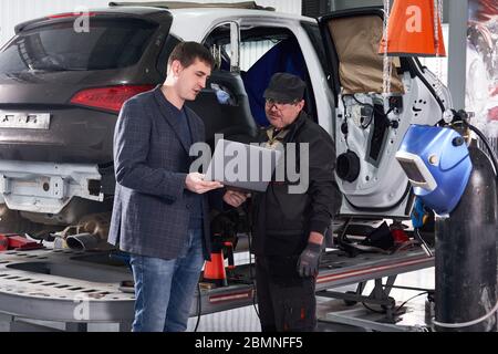 Mécanicien automobile et technicien travaillant dans l'atelier de réparation Banque D'Images