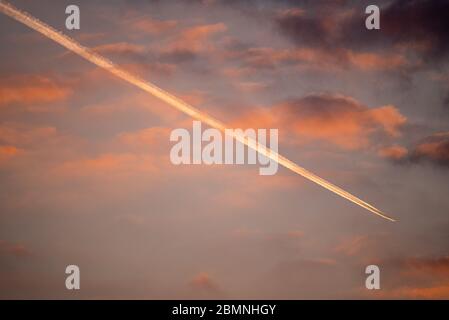 Piste aérienne, piste de vapeur dans le ciel de l'aube en route vers l'aéroport de Heathrow, au-dessus du Hampshire, Royaume-Uni Banque D'Images