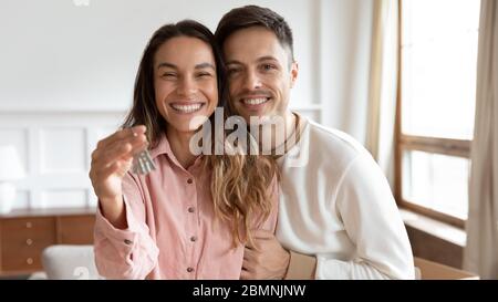 Portrait de tête jeune couple heureux montrant les clés, concept de déplacement Banque D'Images