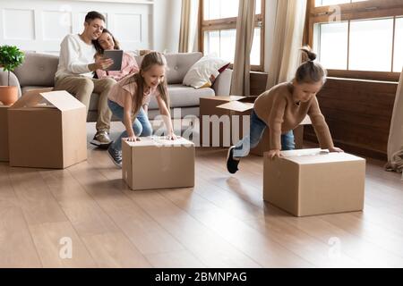 Deux filles aident les parents à se déplacer, en poussant les boîtes en carton Banque D'Images