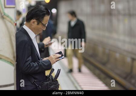 Tokyo / Japon - 19 avril 2018 : homme d'affaires en attente d'un métro à Tokyo Banque D'Images