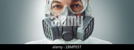 Portrait d'un médecin masculin dans un respirateur, des lunettes et une combinaison de protection biologique contre l'infection à coronavirus. Protection COVID-19. Banque D'Images