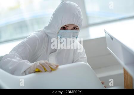 Personne en vêtements de travail de protection qui fait la désinfection à domicile Banque D'Images