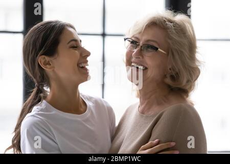 Rire de la mère mature et de la fille adulte profitant de l'instant tendre. Banque D'Images