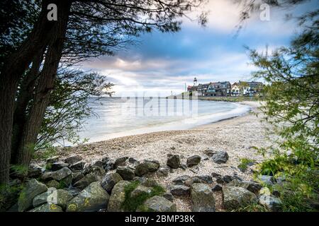 Coucher de soleil sur le phare d'urk sur la plage rocheuse au lac Ijsselmeer par l'ancienne île Urk Flevoland pays-Bas Banque D'Images