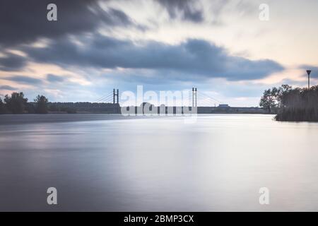 Pont de type télécâblé sur une rivière hollandaise près de la ville de Kampen Overijssel avec un coucher de soleil nuageux Banque D'Images