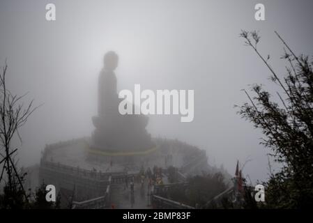 Grande statue de bouddha dans le brouillard au sommet de Phan Xi Păng (Fansipan), avec une foule de touristes insolite, le Vietnam Banque D'Images