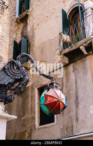 Une lampe de rue inhabituelle en forme de Maforio Dragon au coin du bâtiment, avec une boule de trois parasols - bleu, vert et rouge, sur le Banque D'Images