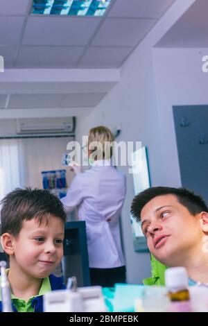 Deux jeunes frères heureux assis dans un bureau de dentiste et attendant un examen dentaire Banque D'Images