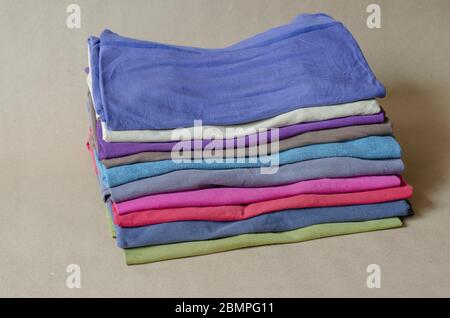 Dix t-shirts de différentes couleurs. Ensemble de t-shirts multicolores. Une pile de t-shirts tendance en gros plan. Tenue confortable et décontractée. Mise au point sélective. Banque D'Images