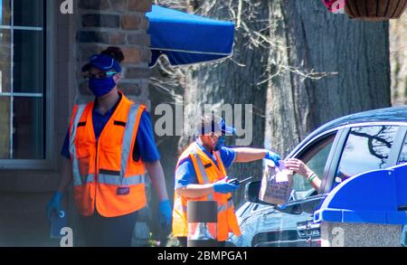 1 mai 2020 Stevensville MI USA; les travailleurs portent des gants et des masques pour livrer de la nourriture aux personnes dans les voitures qui ont besoin de nourriture à emporter dans ce remorquage verrouillé Michigan Banque D'Images