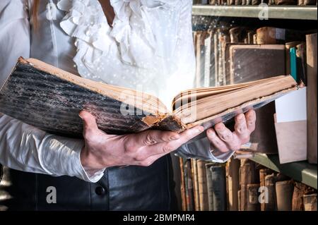 Lumière venant de vieux livre entre les mains de la femme. Concept de sagesse, lecture Banque D'Images