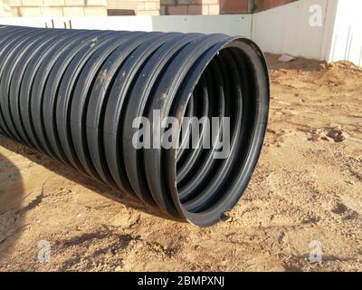 Tuyau annelé de drainage en plastique PVC noir perforé pour la canalisation d'eau Banque D'Images