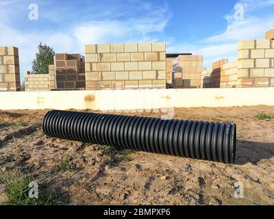 Tuyau annelé de drainage en plastique PVC noir perforé pour la canalisation d'eau Banque D'Images