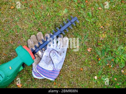 49 taille-haies à haut bas et une paire de gants de jardinage sur une pelouse dans la campagne anglaise Banque D'Images