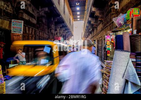 L'agitation du trafic piétonnier et touk-tuk rivalisant pour l'espace dans la zone des fabricants de tentes du bazar Khan El-Khalili Banque D'Images