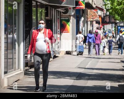 BELGRADE, SERBIE - 27 AVRIL 2020 : jeune femme enceinte portant un masque respiratoire tout en s'attendant à ce que son bébé marche dans la rue de Belgrade, du Banque D'Images