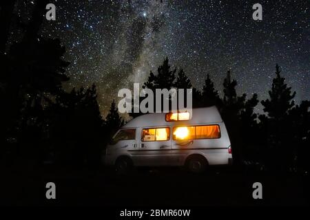 Une autocaravanes garée sous la galaxie de la voie lactée, qui s'élève dans une petite forêt près de Blenheim, Malborough, Nouvelle-Zélande, 2019 Banque D'Images