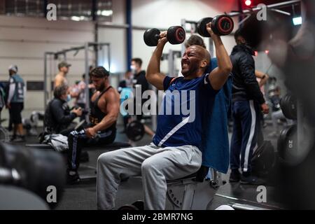 Cologne, Allemagne. 11 mai 2020. Un homme s'entraîne avec des haltères dans une salle de gym de la chaîne McFit. À NRW, les premiers studios de fitness ont rouvert après leur pause Corona dans la nuit du lundi au lundi. Crédit : Marius Becker/dpa/Alay Live News Banque D'Images