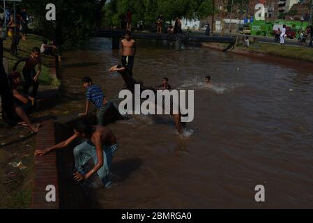 Lahore, Pakistan. 10 mai 2020. Un jeune pakistanais qui profite d'un bain dans l'eau du canal pour combattre la chaleur et se soulager du temps chaud à Ramazan-ul-Mubarak à Lahore. (Photo de Rana Sajid Hussain/Pacific Press) crédit: Pacific Press Agency/Alay Live News Banque D'Images