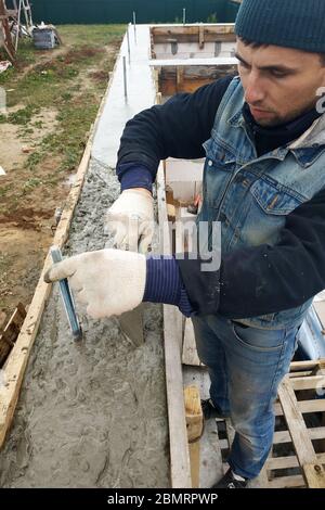 Les lignes de travail le béton dans le travail de coffrage avec truelle, la construction de la nouvelle maison.2020 Banque D'Images