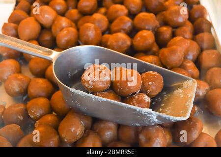 Beaucoup de petits beignets ronds frits, simples, sans sirop ni sauce. Grand bol de beignets isolés, prêts à être servis pendant le festival de la nourriture ou c Banque D'Images