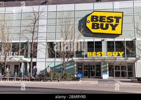 Les clients qui pratiquent la distanciation sociale en ligne à l'extérieur d'un magasin Best Buy au centre-ville de Toronto. Banque D'Images