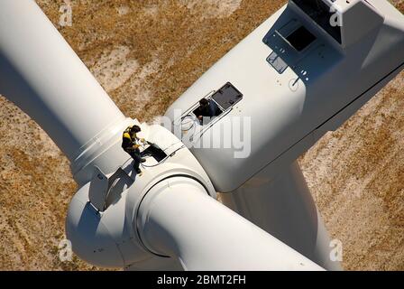 Vue aérienne rapprochée des ingénieurs portant des harnais, travaillant sur une éolienne Banque D'Images