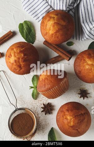 Composition avec muffins et cannelle sur fond blanc Banque D'Images