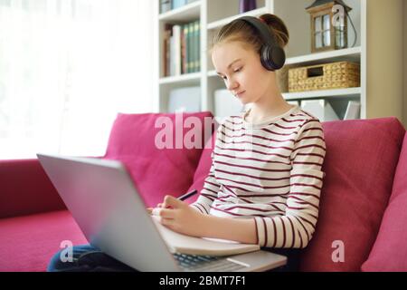 Préteen écolière faire ses devoirs avec ordinateur portable à la maison. Enfant utilisant des gadgets pour étudier. Éducation en ligne et apprentissage à distance pour les enfants. CDM Banque D'Images