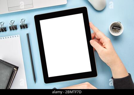 Image de maquette des mains tenant une tablette numérique avec écran blanc vierge sur une surface bleue. Pose à plat Banque D'Images