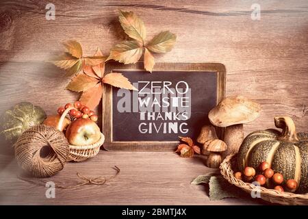 Arrangement rustique d'automne avec le texte 'Zero Waste Thanksgiving' sur un tableau de craie. Décorations naturelles d'automne avec baies, feuilles d'automne, baies rowan rouges Banque D'Images