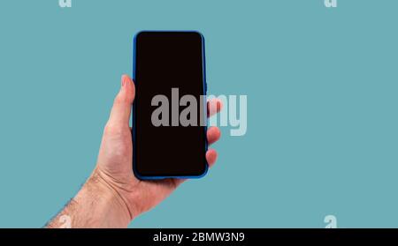 smartphone utilisé par l'homme sur fond bleu Banque D'Images