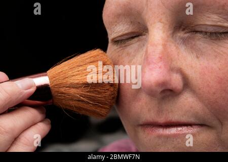 Femme qui pose le maquillage du visage Banque D'Images