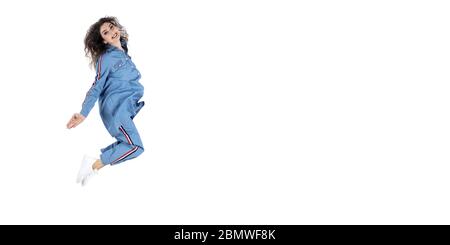 Portrait de fille positive gaie sautant dans l'air avec des poings élevés regardant sur fond violet. Concept d'énergie de la vie Banque D'Images