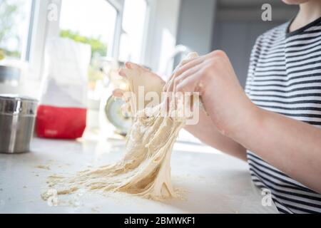 Gros plan Portrait de fille avec des mains salissantes avoir du plaisir dans la cuisine pétrissage de la pâte pour la cuisson Banque D'Images