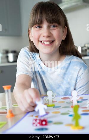 Fille souriante jouant à jeu de société générique à la maison Banque D'Images