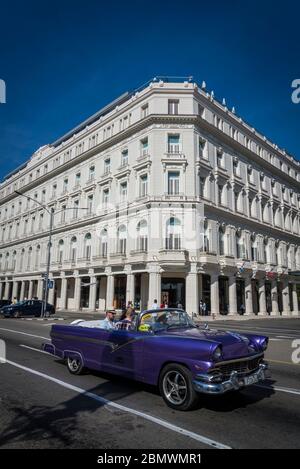 Passage d'une voiture classique par le Gran Hotel Manzana Kempinski la Habana est un hôtel de luxe situé dans le bâtiment historique Manzana de Gomez, Parque Central, HAV Banque D'Images