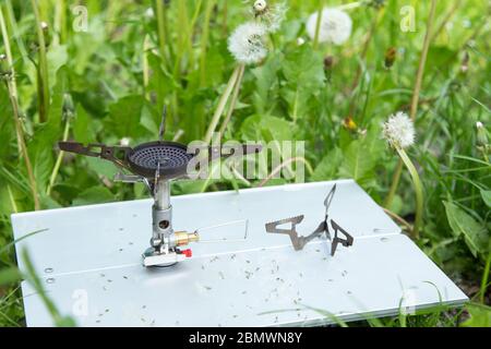 brûleur à gaz touristique sur une petite table dans l'herbe. Banque D'Images