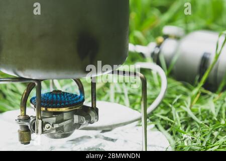 Cuisiner dans une casserole sur un brûleur à gaz touristique. Banque D'Images