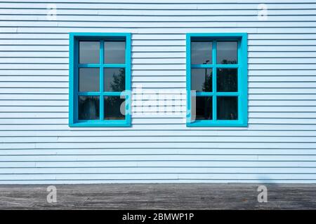 extérieur d'un bâtiment en panneaux de peinture bleus avec deux fenêtres. Banque D'Images