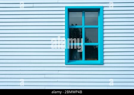 Côté d'un bâtiment en panneaux de rideau avec fenêtre, peint en bleu. Banque D'Images