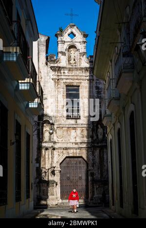 Femme aux jambes négatives marchant dans une rue étroite typique derrière la cathédrale dans le centre de la vieille ville, la Havane Vieja, la Havane, Cuba Banque D'Images